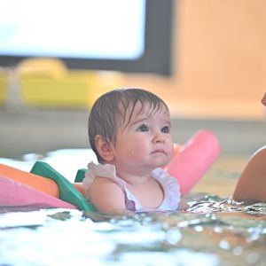 Maman plongeant son enfant dans l'eau