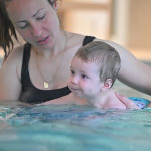 Maman et bébé dans la piscine en train de nager