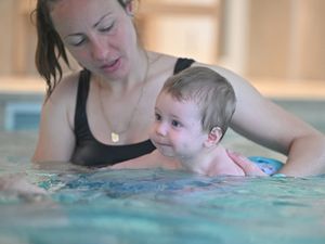 Maman et bébé dans la piscine en train de nager