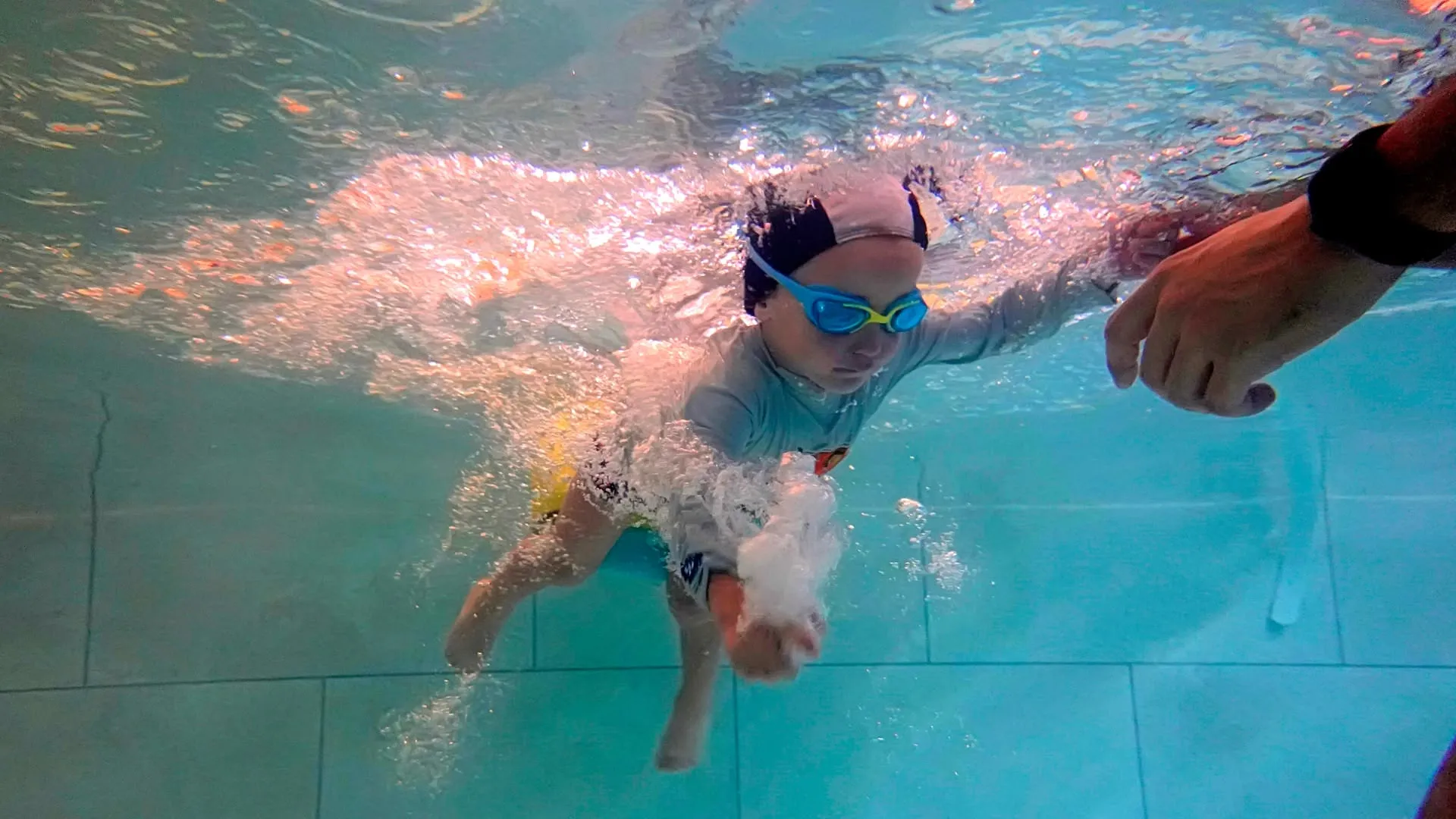 Enfant apprenant à nager avec le maître nageur