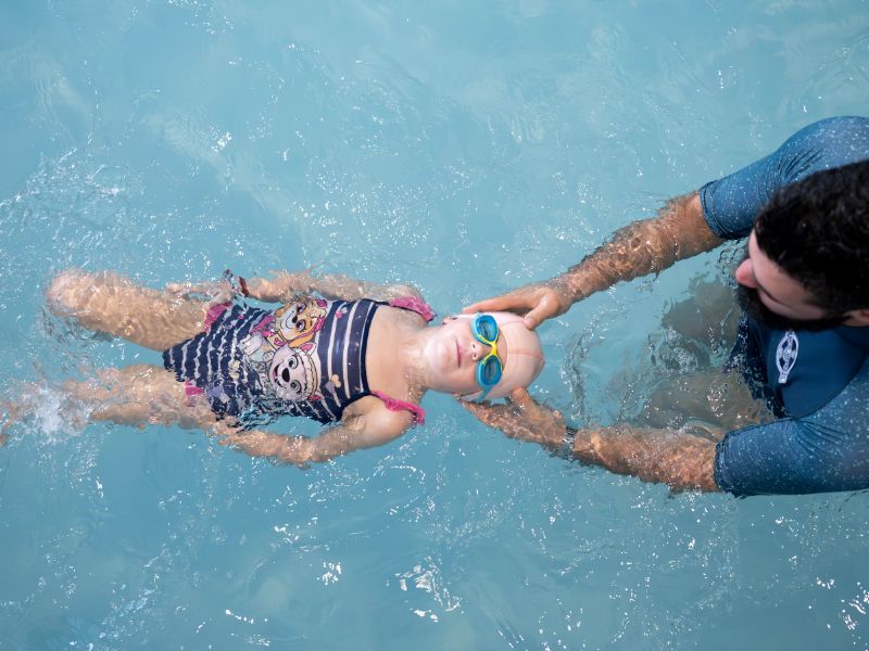 Fillette nageant sous l'eau en souriant