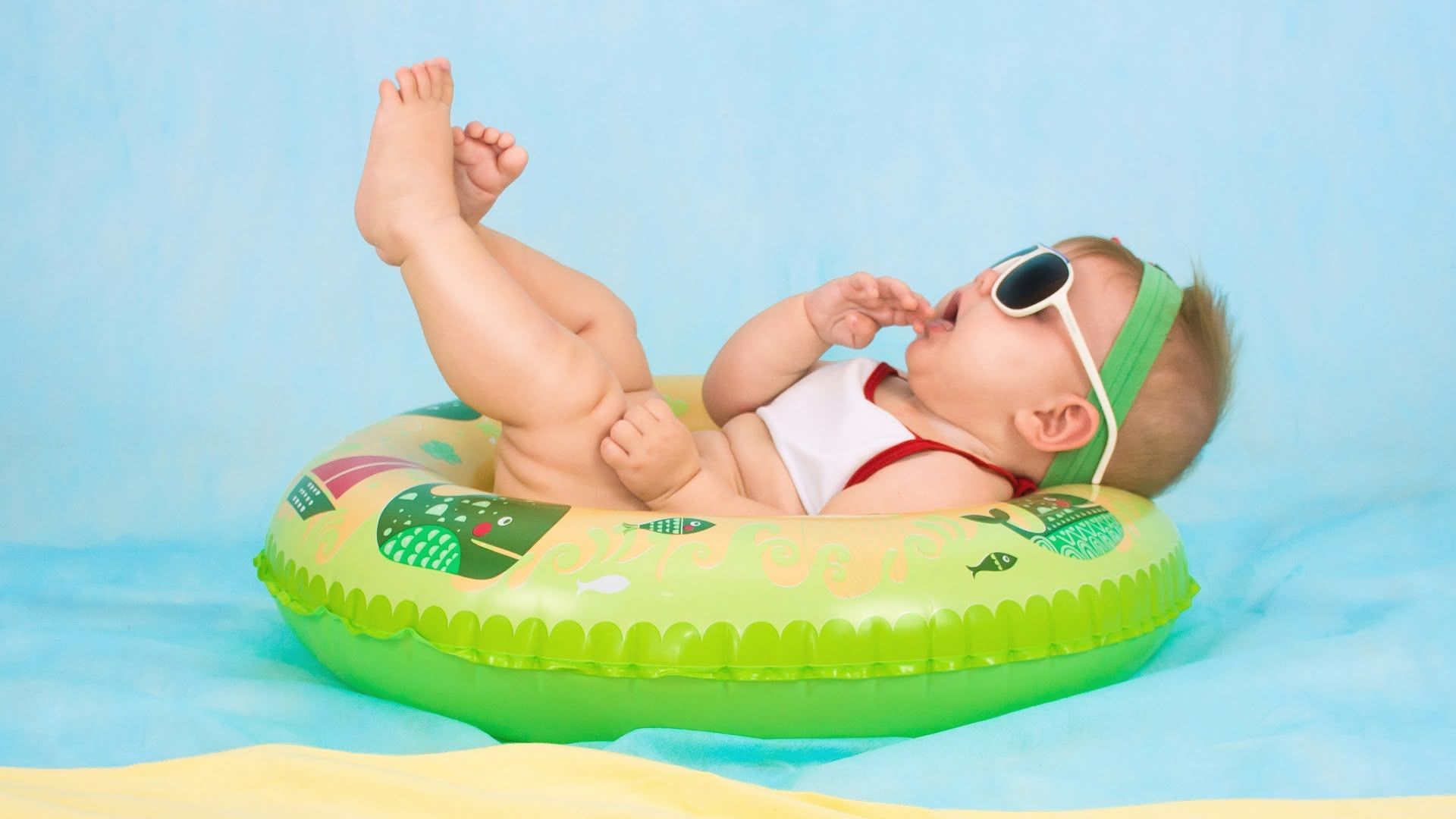 Bébé sur une bouée dans la piscine avec des lunettes de soleil